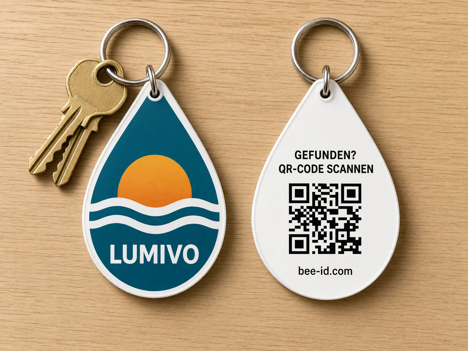 Zwei Schlüsselfundmarken in Tropfenform der Beispielmarke LUMIVO Energie: links die Vorderseite mit farbigem Logo, rechts die Rückseite mit Bee-ID-QR-Code und dem Hinweis „Gefunden? QR-Code scannen“