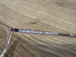 Diskreter Fundservice Sticker auf der Innenseite eines transparenten BrillenbĂźgels